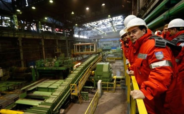 Workers look on at an Evraz steel plant