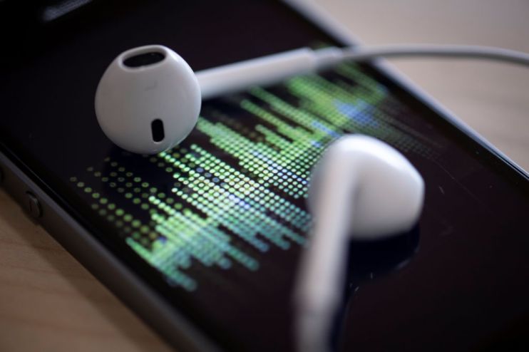 A picture taken on February 8, 2019 in Paris shows a smartphone and its earphones as an audio podcast is being played. (Photo by Thomas SAMSON / AFP) (Photo credit should read THOMAS SAMSON/AFP/Getty Images)