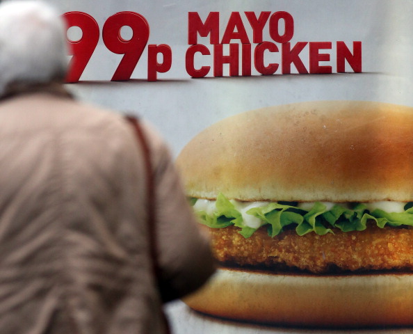 BRISTOL, ENGLAND - JANUARY 07: A woman passes an advertisement outside a fast food outlet on January 7, 2013 in Bristol, England. A government-backed TV advert - made by Aardman, the creators of Wallace and Gromit - to promote healthy eating in England, is to be shown for the first time later today. England has one of the highest rates of obesity in Europe - costing the NHS 5 billion GDP each year - with currently over 60 percent of adults and a third of 10 and 11 year olds thought to be overweight or obese. (Photo by Matt Cardy/Getty Images)