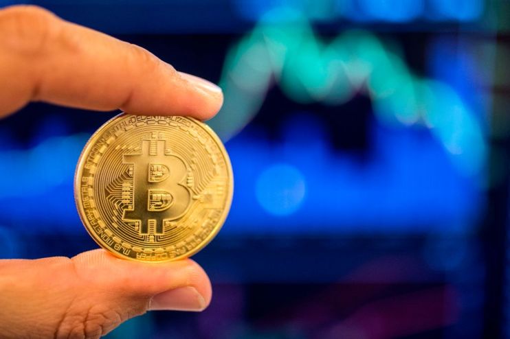 A picture taken on February 6, 2018 shows a person holding a visual representation of the digital crypto-currency Bitcoin, at the "Bitcoin Change" shop in the Israeli city of Tel Aviv. / AFP PHOTO / JACK GUEZ (Photo credit should read JACK GUEZ/AFP/Getty Images)