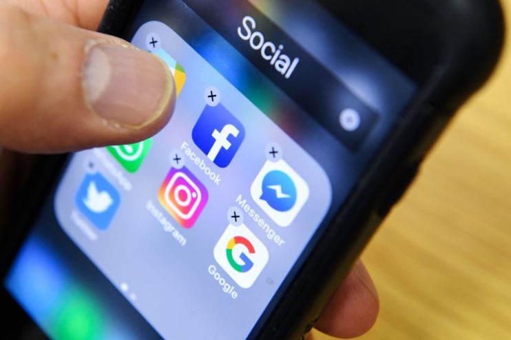 A man holds a smart phone with the icons for the social networking apps Facebook, Instagram and Twitter seen on the screen in Moscow on March 23, 2018. - A public apology by Facebook chief Mark Zuckerberg, on March 22, 2018 failed to quell outrage over the hijacking of personal data from millions of people, as critics demanded the social media giant go much further to protect privacy. (Photo by Kirill KUDRYAVTSEV / AFP) (Photo credit should read KIRILL KUDRYAVTSEV/AFP/Getty Images)