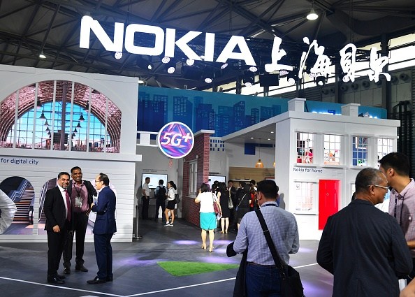 This photo taken on June 27, 2018 shows people gathering at a Nokia booth during the Mobile World Conference in Shanghai. (Photo by - / AFP) / China OUT (Photo credit should read -/AFP/Getty Images)