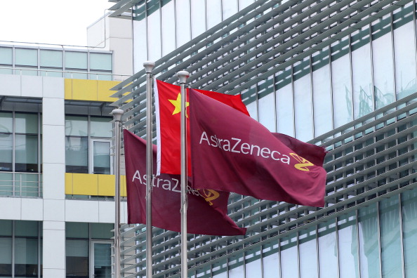 Company flags fly next to the Chinese one outside the headquarters of Britain's AstraZenica China headquarters in the Zhangjiang district of Shanghai on July 24, 2013. Beijing's targeting of British pharmaceutical giant GlaxoSmithKline (GSK) in a high-profile bribery probe is a reminder of the risks foreign companies face when seeking the huge rewards of China's market, analysts say. Police say GSK staff offered government officials and doctors bribes, and took kick-backs from travel agencies to organise conferences, some of which were fake. Chinese authorities have also questioned three Shanghai-based employees of Britain's AstraZeneca, detaining two, and have visited the offices of Belgium's UCB, according to the companies, although they did not specify what was being investigated. CHINA OUT AFP PHOTO (Photo credit should read STR/AFP/Getty Images)