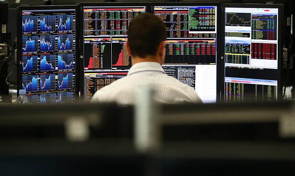 LONDON, ENGLAND - OCTOBER 20: An employee views trading screens at the offices of Panmure Gordon and Co on October 20, 2014 in London, England. Markets stabilised over the weekend following global turbulence amid fears over the Ebola virus and global economic concerns. (Photo by Carl Court/Getty Images)