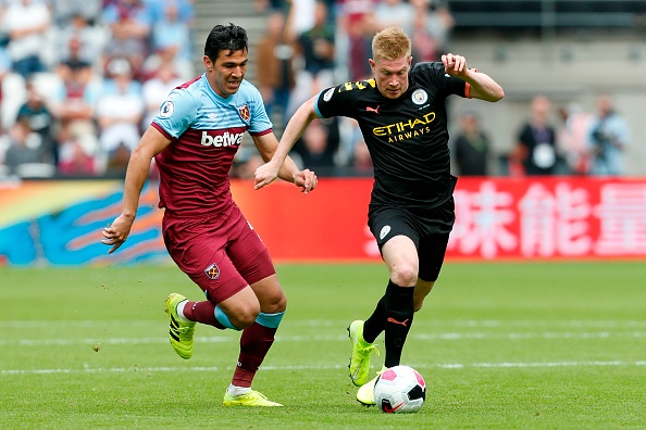 West Ham United's Paraguayan defender Fabián Balbuena (L) chases Manchester City's Belgian midfielder Kevin De Bruyne (R) during the English Premier League football match between West Ham United and Manchester City at The London Stadium, in east London on August 10, 2019. (Photo by Ian KINGTON / AFP) / RESTRICTED TO EDITORIAL USE. No use with unauthorized audio, video, data, fixture lists, club/league logos or 'live' services. Online in-match use limited to 120 images. An additional 40 images may be used in extra time. No video emulation. Social media in-match use limited to 120 images. An additional 40 images may be used in extra time. No use in betting publications, games or single club/league/player publications. / (Photo credit should read IAN KINGTON/AFP/Getty Images)