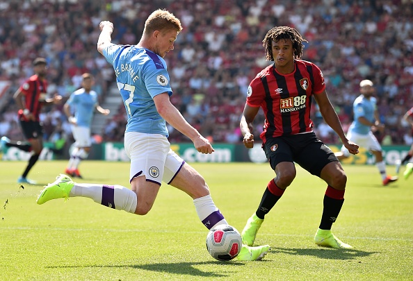 Manchester City's Belgian midfielder Kevin De Bruyne (L) crosses the ball past Bournemouth's Dutch defender Nathan Ake during the English Premier League football match between Bournemouth and Manchester City at the Vitality Stadium in Bournemouth, southern England on August 25, 2019. (Photo by Glyn KIRK / AFP) / RESTRICTED TO EDITORIAL USE. No use with unauthorized audio, video, data, fixture lists, club/league logos or 'live' services. Online in-match use limited to 120 images. An additional 40 images may be used in extra time. No video emulation. Social media in-match use limited to 120 images. An additional 40 images may be used in extra time. No use in betting publications, games or single club/league/player publications. / (Photo credit should read GLYN KIRK/AFP/Getty Images)