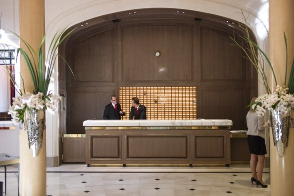 A picture taken on August 19, 2014 at the Plaza Athenee hotel in Paris shows receptionists working at the lobby of the establishment. The Plaza Athenee reopened its doors on September 8,2014 after eleven months following a 200 million-euros extension and renovation. Three adjacent buildings were acquired and are being integrated. AFP PHOTO / FRED DUFOUR (Photo credit should read FRED DUFOUR/AFP/Getty Images)