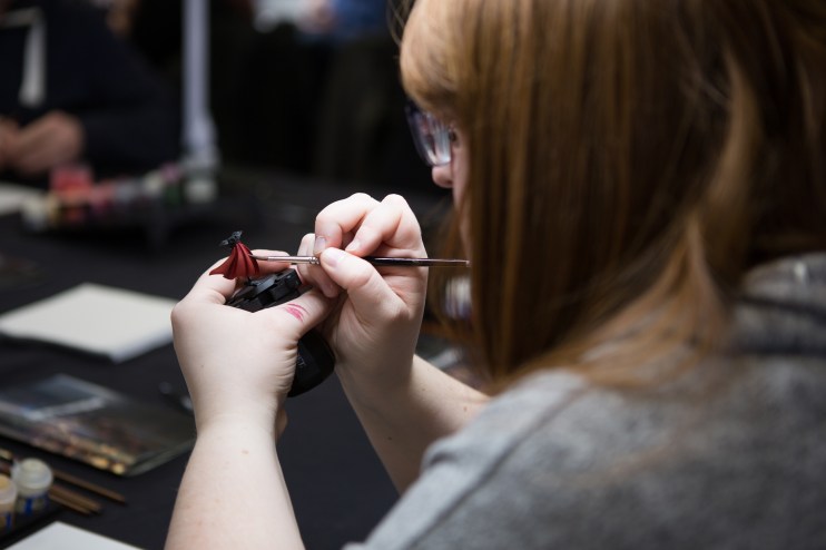 Games Workshop: Woman paints a miniature