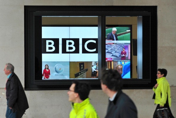 A BBC logo is pictured on a television screen inside the BBC's New Broadcasting House office in central London, on November 12, 2012. The BBC announced that two of its executives were standing aside on Monday and warned more heads may roll as it battles with a major crisis over its reporting of sex abuse that toppled the director-general. AFP PHOTO / CARL COURT (Photo credit should read CARL COURT/AFP via Getty Images)