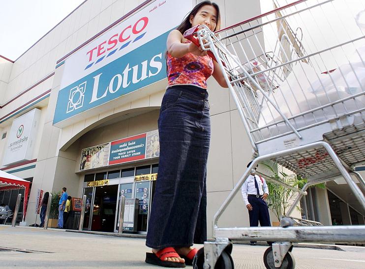 A Thai woman pushes a trolley past the entrance of