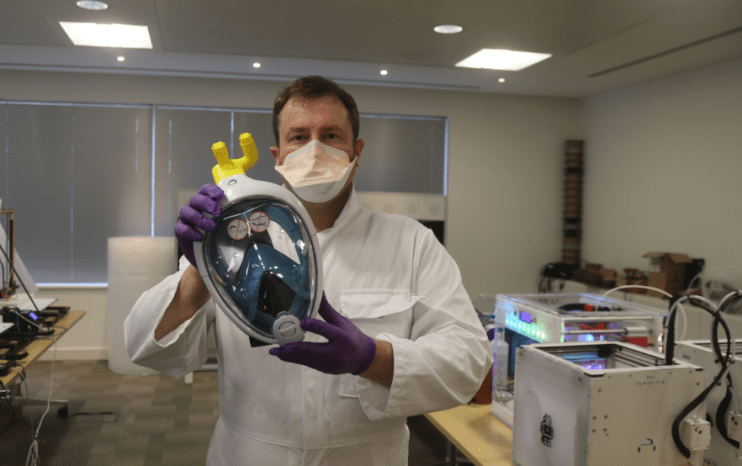 Alex Gibson of Edumaker holds up a coronavirus face mask his company and Cisco have 3D printed in response to NHS demand for PPE kit