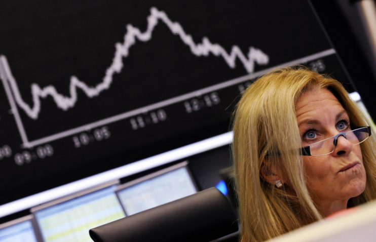 A stock broker looks at her screen at Fr