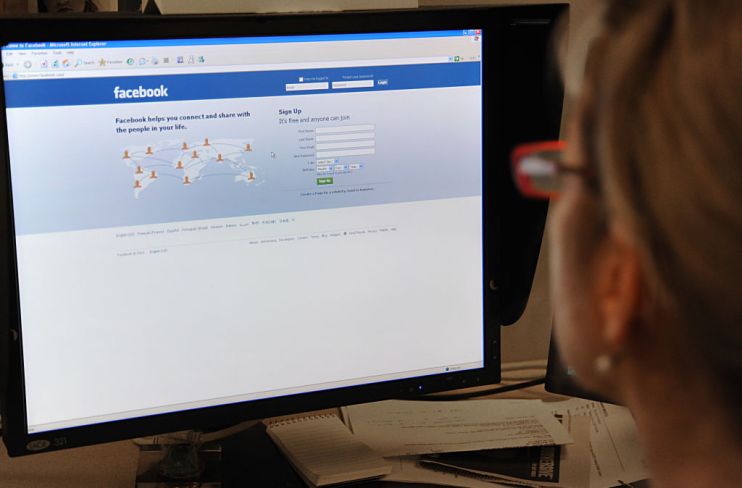 A woman prepares to log on to the Facebo