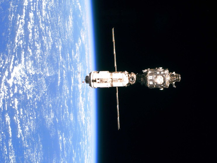 The International Space Station (Iss Is Backdropped Against The Blue And White Horizon Scene Of Ear