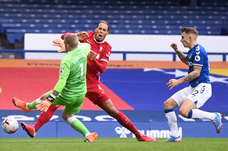 Jordan Pickford of Everton tackles Liverpool's Virgil van Dijk