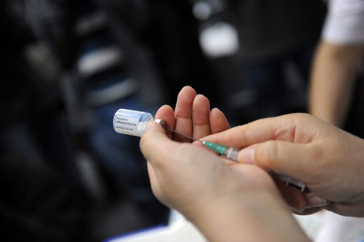 A nurse prepares a shot of the A(H1N1) v