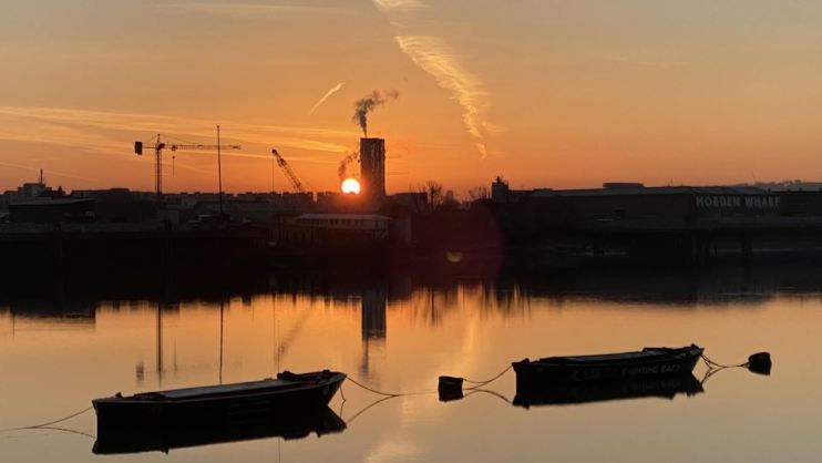 Sun behind Morden Wharf, London