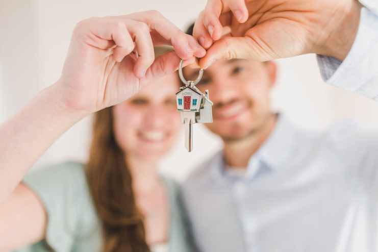 woman holding silver and gold key