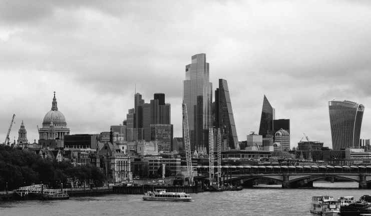 grayscale photo of city buildings near body of water