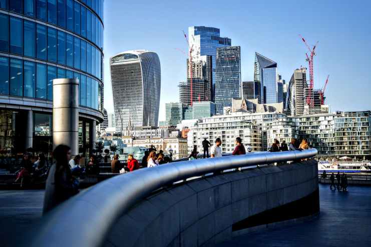 people walking on bridge near high rise buildings