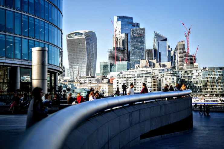 people walking on bridge near high rise buildings
