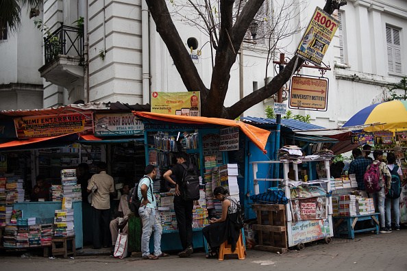 Indian residents shop under tarpaulin at stalls at the book market on Bankim Chatterjee Street (Photo by Rebecca Conway/Getty Images)