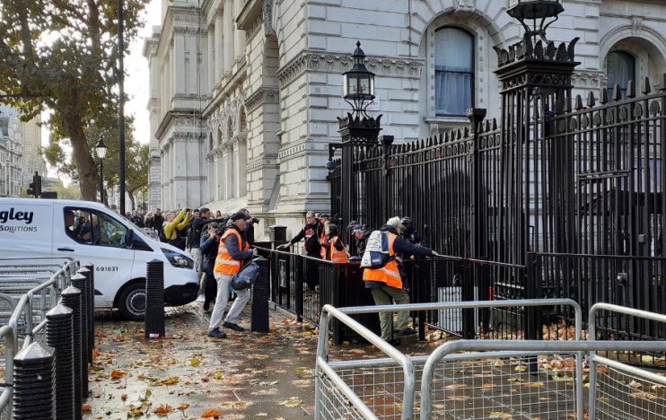 Just Stop Oil demonstrators try to scale Downing Street's famous gates.