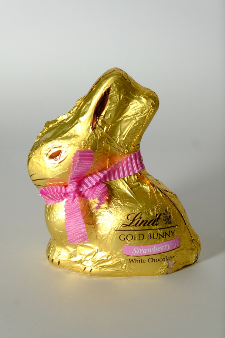 Chocolate Easter bunny surrounded by various themed Easter eggs, including exploding candy and hot cross bun flavors.