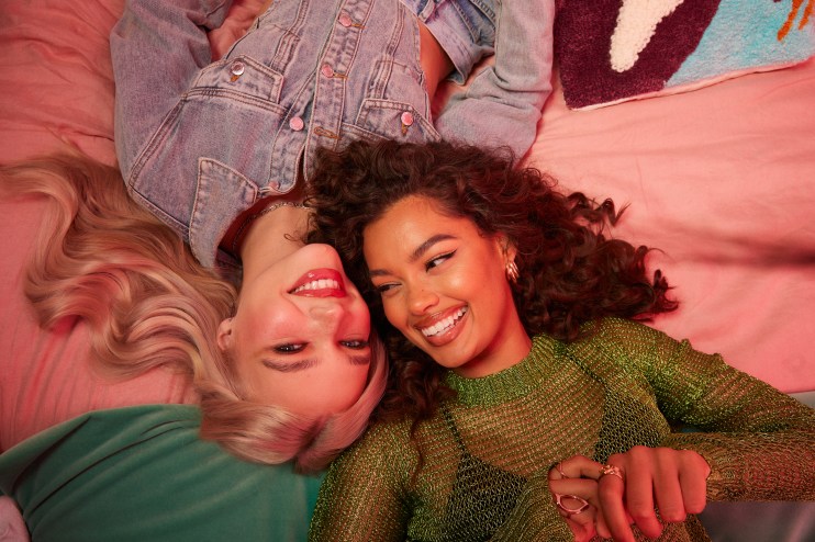 Two girls lay on the floor smiling about buying their best Black Friday deals.