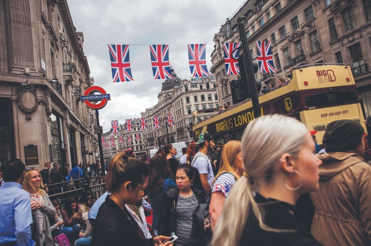 Pedestrians crossed the road at a crossing on Oxford Circus as British Union flags hang above Regent Street in London, U.K., on Tuesday, May 24, 2016. U.K. retail sales began the second quarter with more momentum than economists forecast. Photographer: Simon Dawson/Bloomberg via Getty Images