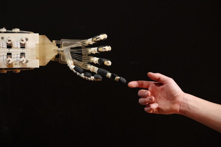 LONDON, ENGLAND - NOVEMBER 29: Robotics student Gildo Andreoni interacts with a Dexmart robotic hand built at the University of Bologna in the Robotville exhibition at the Science Museum on November 29, 2011 in London, England. The Science Museum's Robotville exhibition showcases 20 unique and cutting-edge robots from European research laboratories, it is free to enter and runs from December 1-4, 2011. (Photo by Oli Scarff/Getty Images)