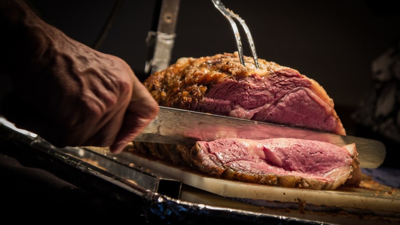 A person cutting a joint of beef