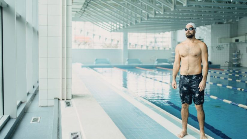 Public swimming pool with diverse people enjoying leisure, reflecting solitude and community from Manchester to New Delhi