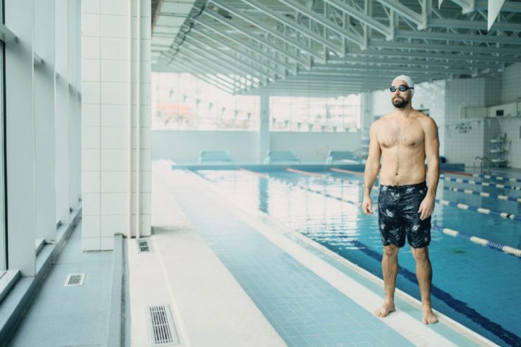 Public swimming pool with diverse people enjoying leisure, reflecting solitude and community from Manchester to New Delhi