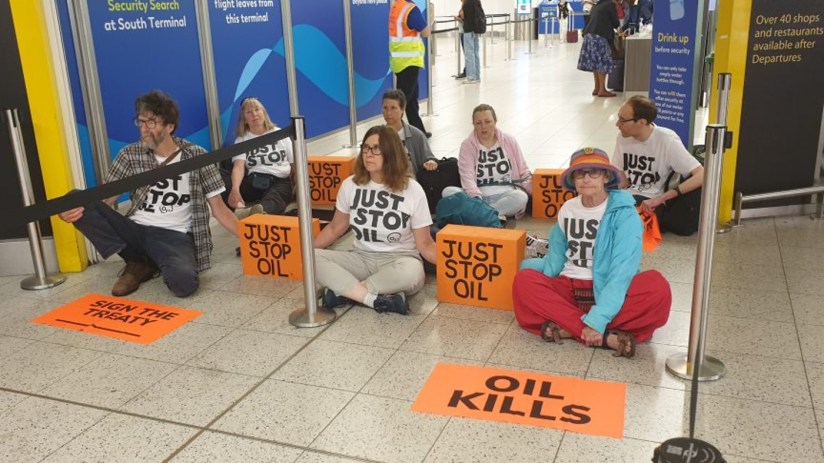 Just Stop Oil activists block a departure gate at Gatwick. Credit: Just stop Oil
