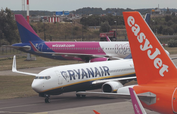 The forecasts from Ryanair, Europe's largest airline by passenger numbers, echo wider industry warnings of downward pressure on ticket prices. (A RyanAir passenger plane taxis past planes of other discount airliners Wizz Air and EasyJet at Schoenefeld Airport. (Photo by Sean Gallup/Getty Images))