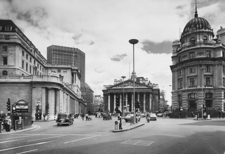 The Bank of England (left) and the London Stock Exchange (behind), with the neoclassical Royal Exchange building (centre), and the offices of the Royal Insurance Group (right), on Bank Junction in Canada, England, June 1974. Bank London Underground station is visible in the lower lefthand corner of the frame. (Photo by Phillips/Fox Photos/Hulton Archive/Getty Images)