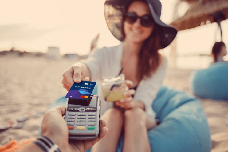Person paying taxes online on a laptop at a beach, illustrating UK tax obligations despite living abroad