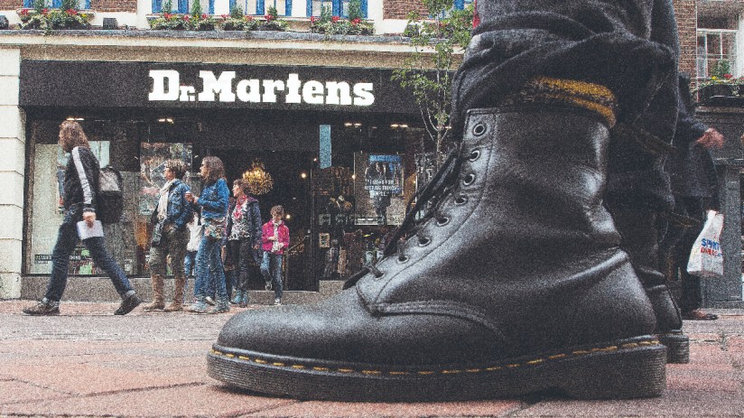 (A pedestrian wearing Dr. Martens boots poses for a photograph outside the footwear company's store in Convent Garden in London (Photographer: Simon Dawson/Bloomberg via Getty Images))