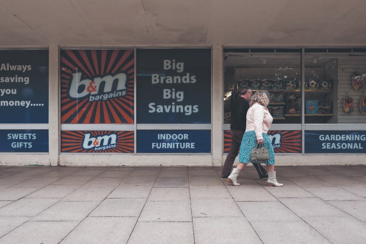 Members of the public walks past a branch of high street retailer B&M advertising big brands and big savings. (photo by Daniel Harvey Gonzalez/In Pictures via Getty Images)