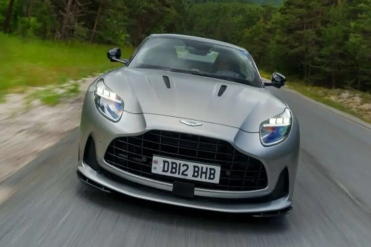 Aston Martin headquarters with company logo, highlighting job cuts and financial struggles amid tariff impacts