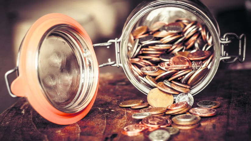 Jar filled with coins symbolizing cautious saving habits of older Brits avoiding stock market investments for retirement s...