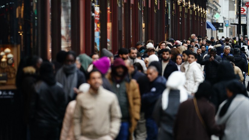 Shoppers wait in line for the start of the Boxing Day sales at the Harrods store in Knightsbridge, London. Photo credit: Jordan Pettitt/PA Wire