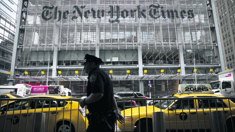 An New York City Police Department (NYPD) police officer passes in front of The New York Times Co. offices in New York, U.S. (Photographer: Scott Eells/Bloomberg via Getty Images)
