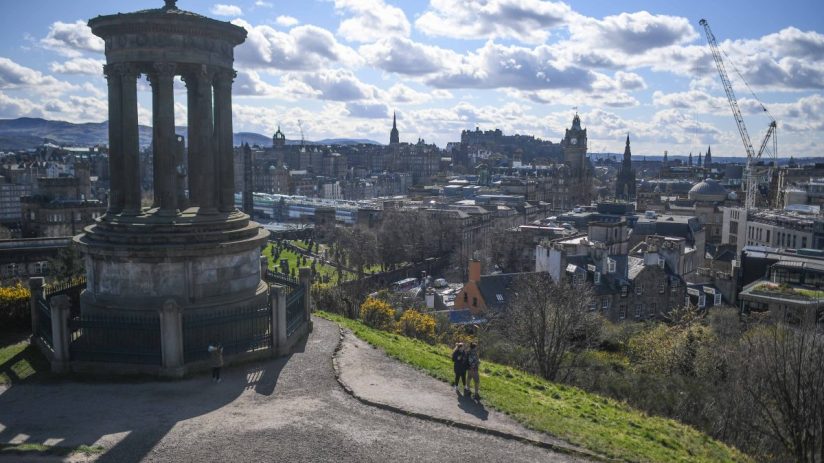 EDINBURGH, SCOTLAND - APRIL 09: People jog at Calton Hill Cemetery overlooking the Old Town with Dugald Stewart Monument on Calton Hill as the country responds to the announcement that Prince Philip, Duke Of Edinburgh has died at age 99 on April 9, 2021 in Edinburgh, United Kingdom. The Queen has announced the death of her beloved husband, His Royal Highness Prince Philip, Duke of Edinburgh. HRH passed away peacefully this morning at Windsor Castle. (Photo by Peter Summers/Getty Images)