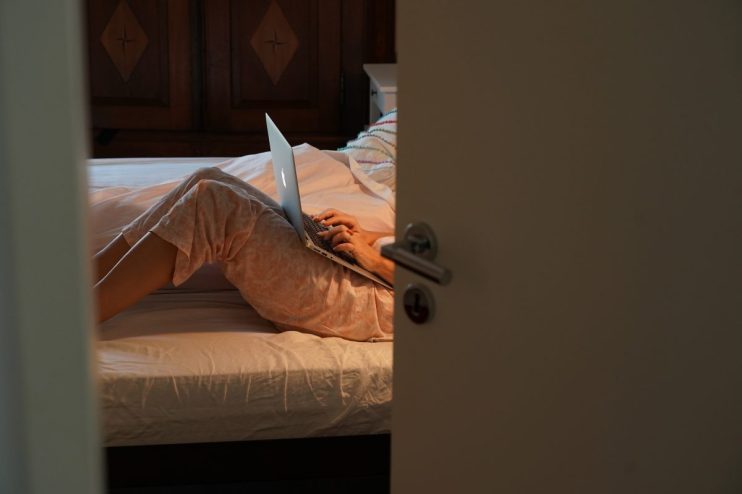 BERLIN, GERMANY - OCTOBER 29: Johana, the wife of the photographer, works on her laptop computer in their bed during her isolation for a Covid-19 infection on the 2nd day of his 14-day quarantine at home during the second wave of the coronavirus pandemic on October 29, 2020 in Berlin, Germany. The photographer went into mandated quarantine following the positive Covid-19 infection of his wife. After three days of fever and headaches she made a speedy recovery, has shown no lingering consequences and finished her mandated isolation at home on November 3. In keeping with Berlin city health guidelines the photographer began his 14-day quarantine after the last day his wife showed infection symptoms and passed the time in their apartment with home office work for his employer, cooking, household upkeep, bicycle maintenance, reading and following the outcome of the U.S. presidential election. He also underwent a Covid test, which returned with a negative result. (Photo by Sean Gallup/Getty Images)