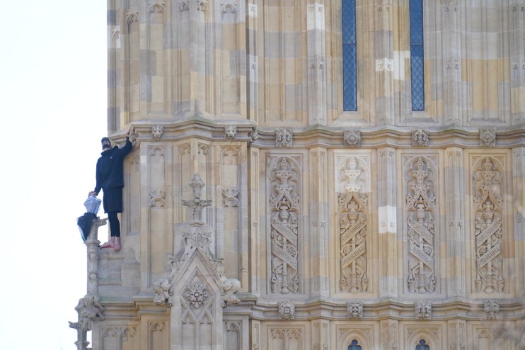 People watch a man with a Palestine flag after he climbed up Elizabeth Tower, which houses Big Ben at the Palace of Westminster in London. Picture date: Saturday March 8, 2025. James Manning/PA Wire Copyright notice: &copy; 2025 PA Media, All Rights Reserved