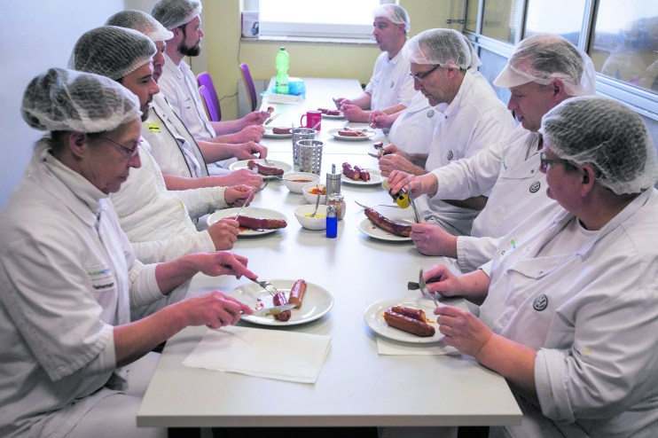 Members of the production team eat currywurst sausages during the daily 10:00am tasting session in the Volkswagen AG (VW) manufacturing plant in Wolfsburg, Germany, on Thursday, March 12, 2020. This week VW made its highest employee bonus payment since 2015, the automaker's works council said in a staff newsletter. Photographer: Krisztian Bocsi/Bloomberg via Getty Images