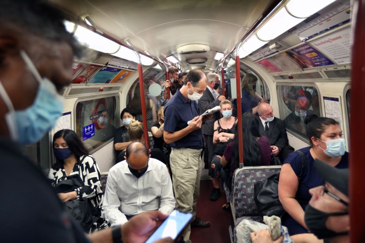 LONDON, ENGLAND - JULY 19: Passengers on a busy Bakerloo line train going north at rush hour with most commuters wearing face coverings on July 19, 2021 in London, United Kingdom. As of 12:01 on Monday, July 19, England will drop most of its remaining Covid-19 social restrictions, such as those requiring indoor mask-wearing and limits on group gatherings, among other rules. These changes come despite rising infections, pitting the country's vaccination programme against the virus's more contagious Delta variant.