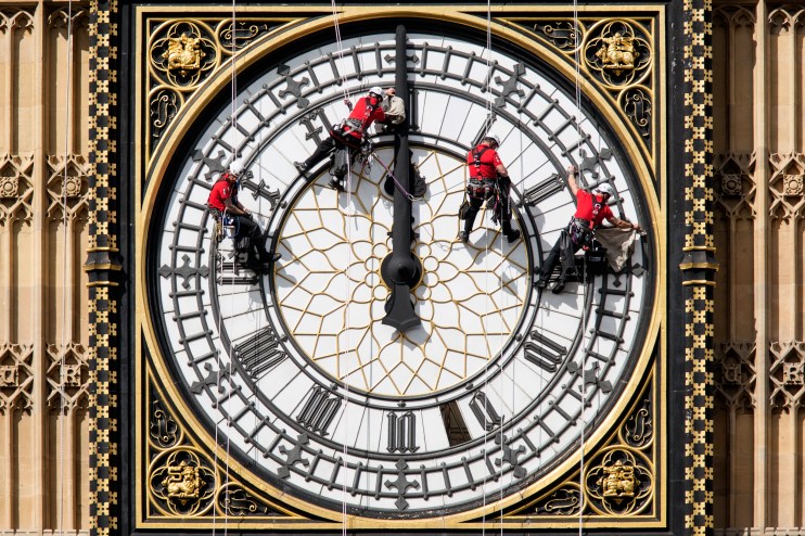 LONDON, ENGLAND - AUGUST 19: Workers clean the East-facing clock face of the Elizabeth Tower of the Houses of Parliament on August 19, 2014 in London, England. Workers are cleaning the four faces of the Great Clock, some 60 meters above ground, which contains the Big Ben bell.
